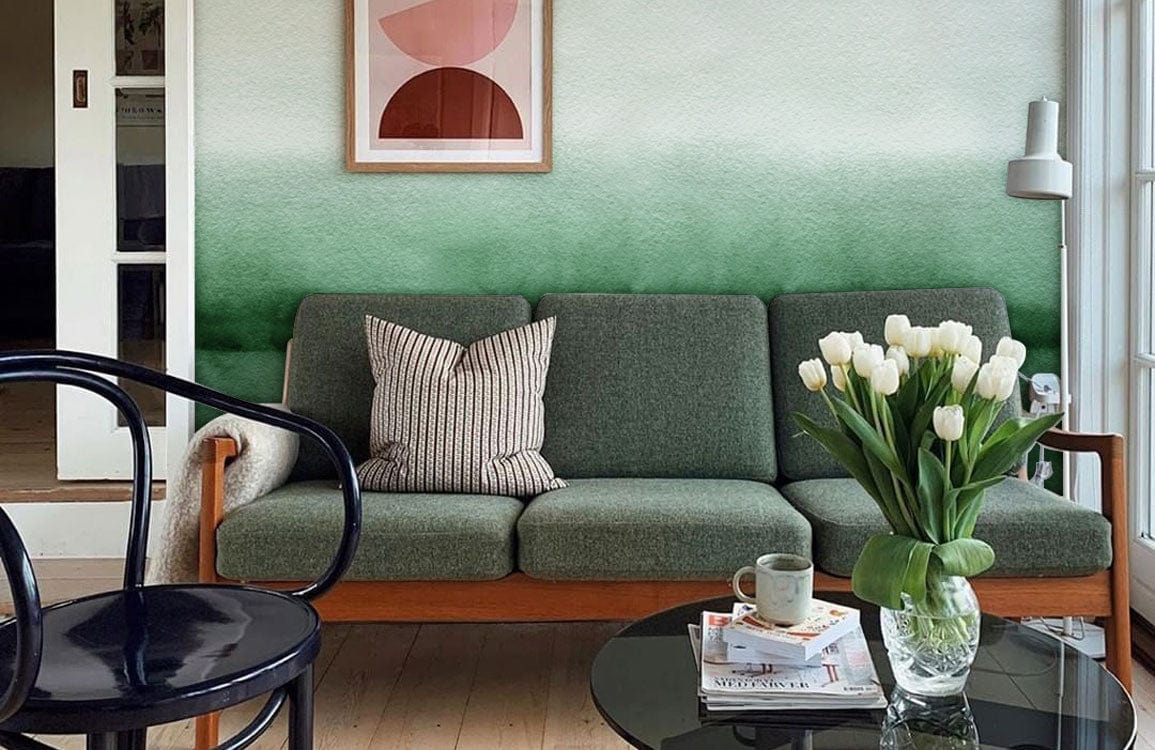 Green Ombre Watercolour Stripes Mural Wallpaper in living room with green sofa, wooden flooring, glass table.