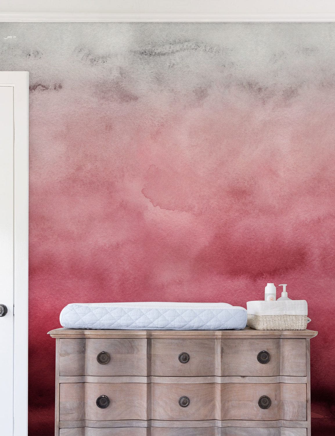 Rosy Ombré wallpaper in elegant red and white; rustic wooden dresser enhances bedroom's artistic design.