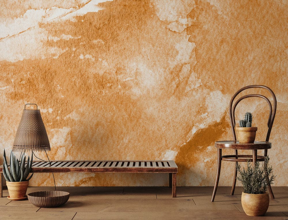 Earthy Watercolour Textured Orange Mural Wallpaper with wooden chair and bench in artistic interior.