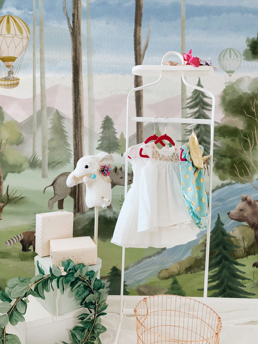 Enchanted Woodland Adventure Mural: Pastel safari dreamscape nursery wallpaper, child's dress rack, white rug.