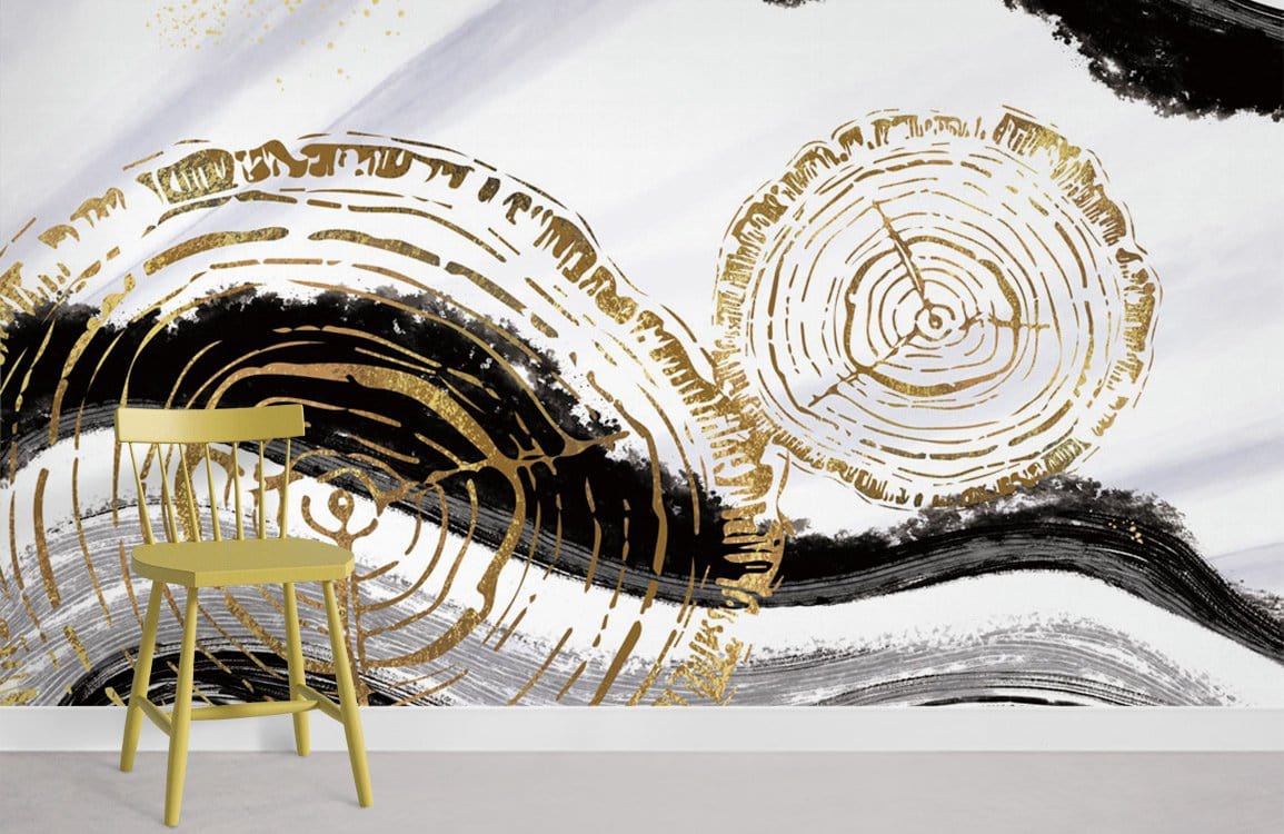 Gold and black abstract tree rings mural wallpaper with yellow chair, minimalistic white setting.