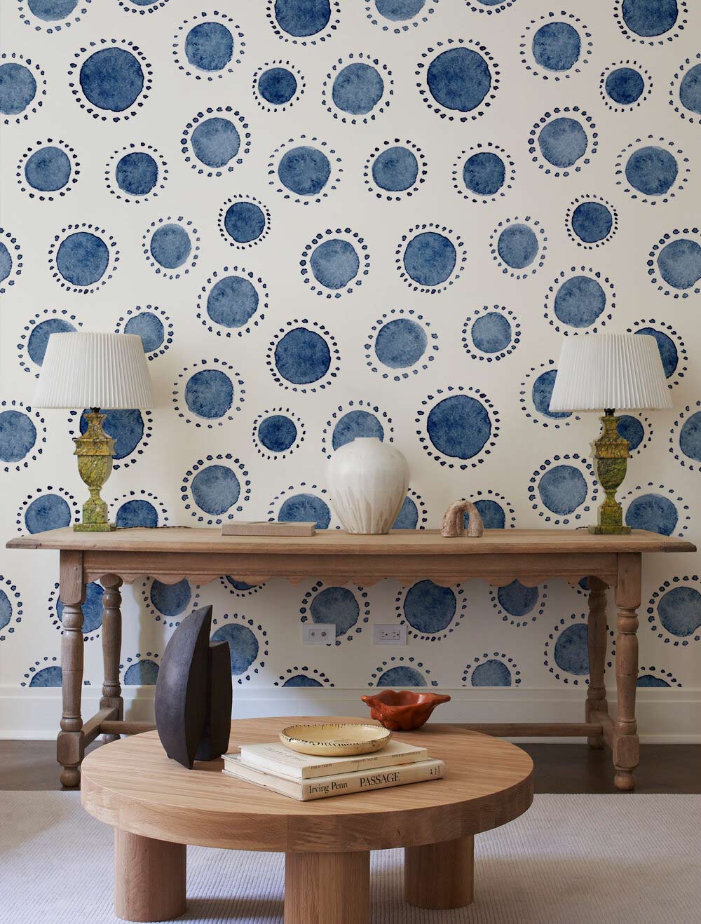 Navy blue polka dot wallpaper with wooden flooring, console table, and modern living room decor.
