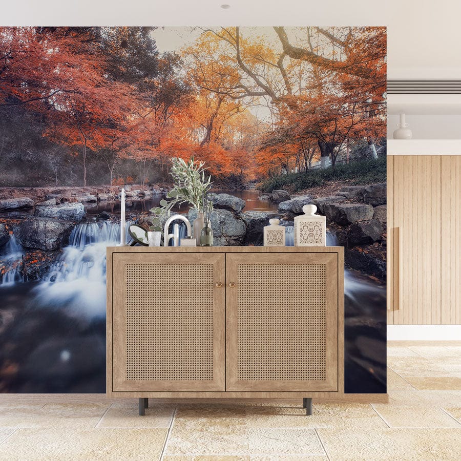 Autumn Serenity Stream Landscape Wallpaper with wooden cabinet, tiled flooring, orange-blue tranquillity scene.