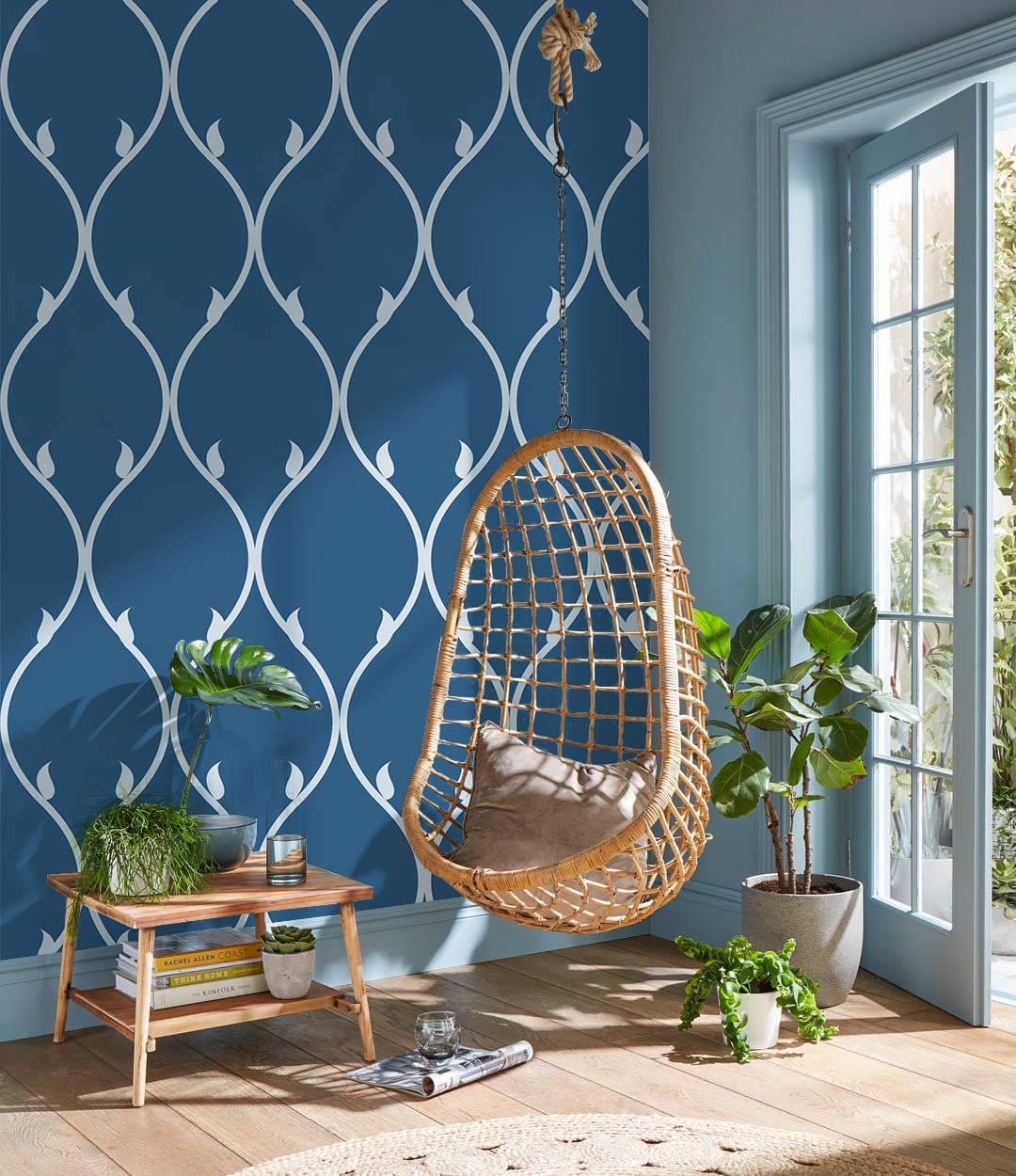 Elegant blue and white geometric wallpaper with rattan swing, wooden flooring, in modern living room.