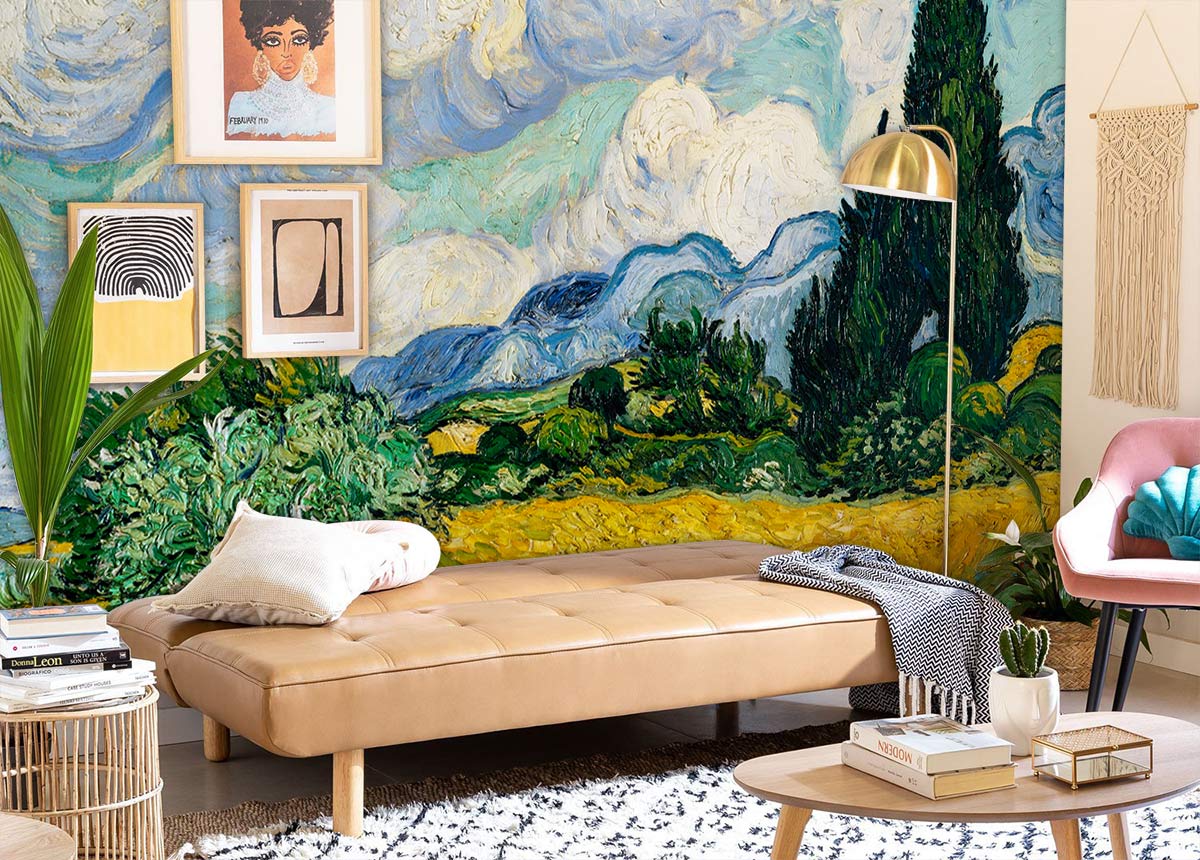 Vibrant mural wallpaper with landscape; beige daybed, pink chair; modern living room decor; wooden flooring.