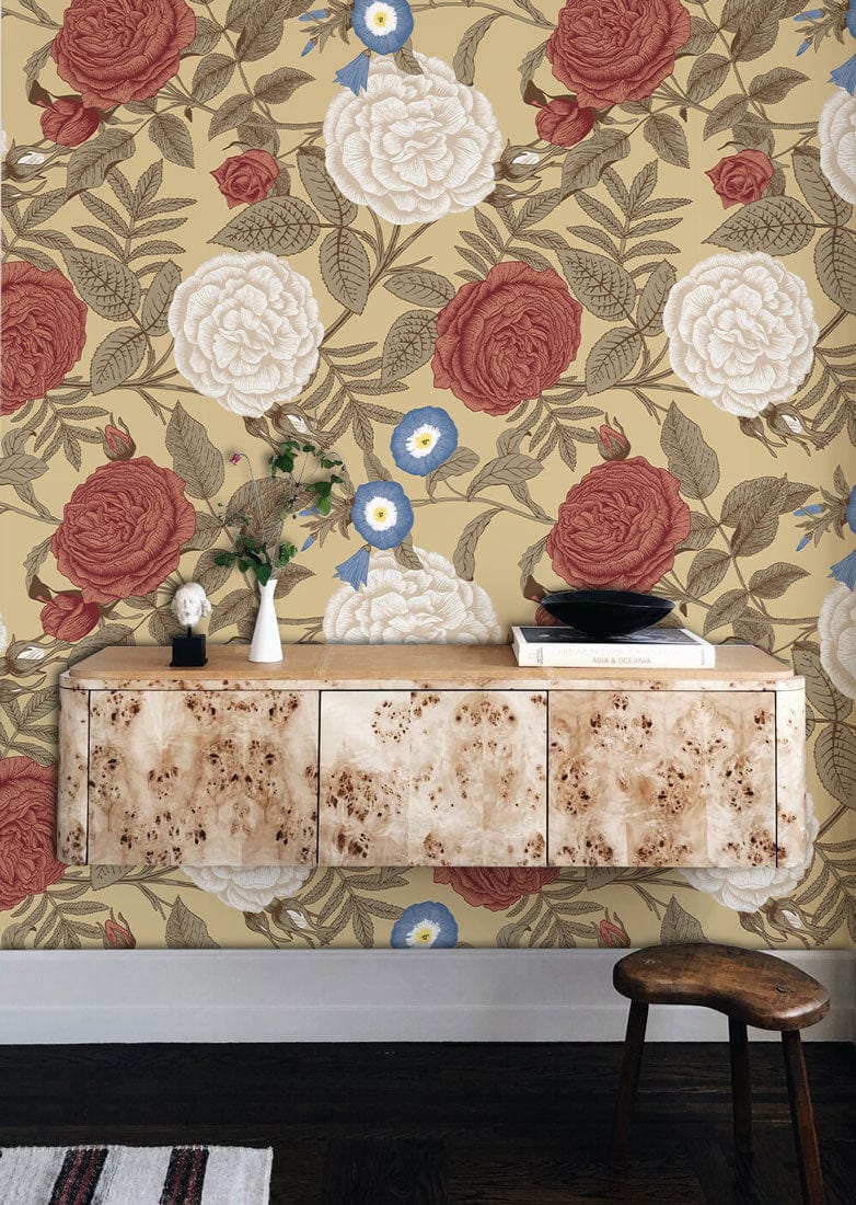 Victorian floral wallpaper with red, white roses; beige background. Vintage console table, wooden flooring.