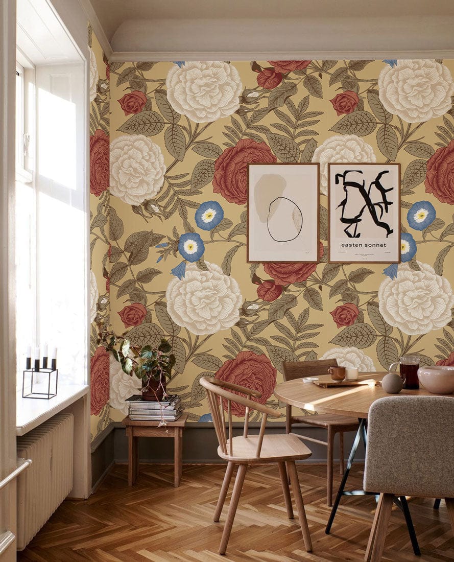 Victorian floral wallpaper with red, white roses, beige background; wooden chairs, round table, parquet flooring.