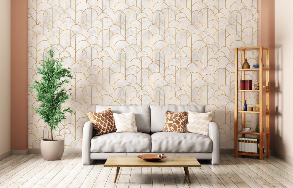 Art Deco wallpaper with gold-white scallop pattern, grey sofa, wooden flooring, decorative cushions, elegant room.
