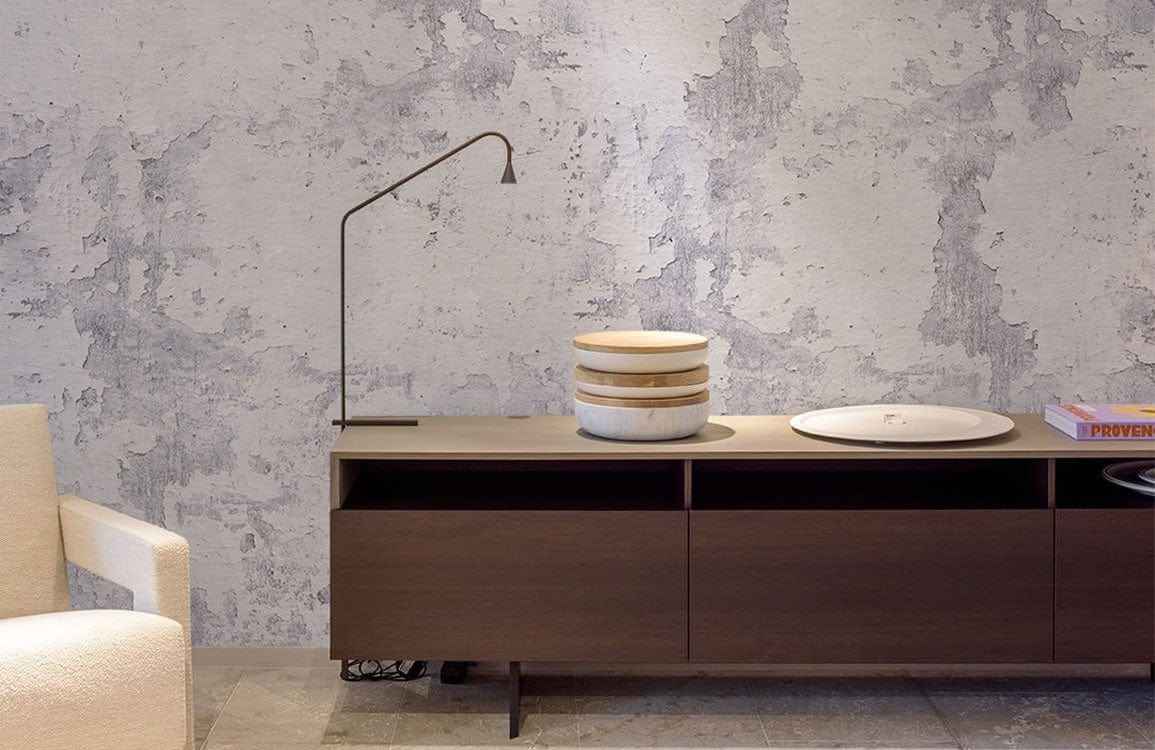 Vintage industrial grey concrete wallpaper with sideboard, modern lamp, cream sofa, and stone flooring.