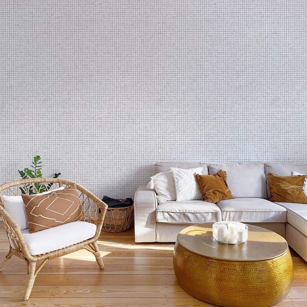 Elegant white grid wallpaper, modern chic lounge, wicker chair, white sofa, gold coffee table, wood floor.