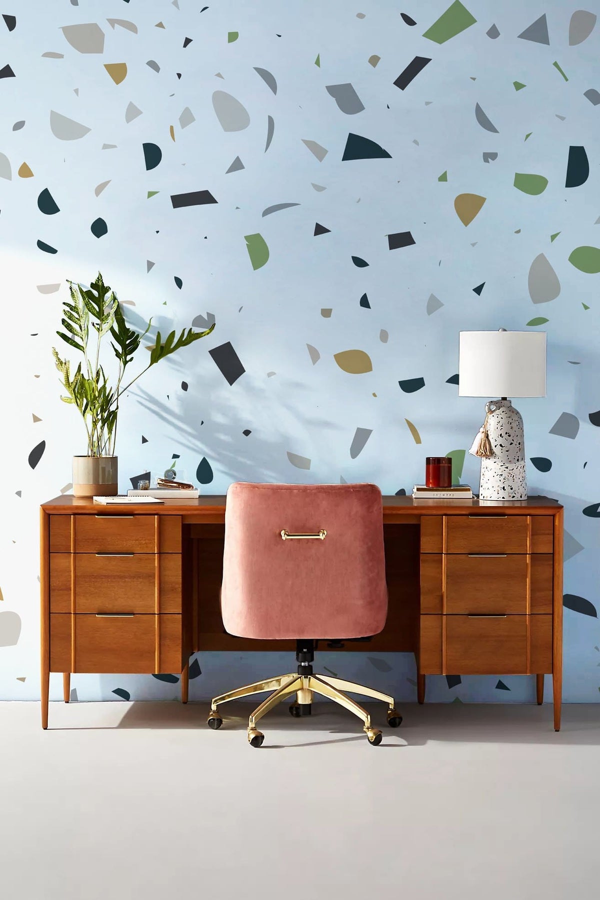 Modern Green Terrazzo wallpaper, wooden desk, pink chair, table lamp; stylish study room Décor.