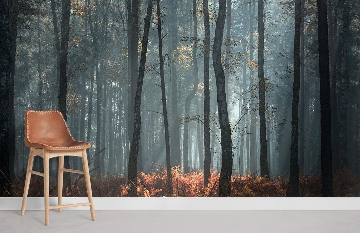 Enchanting forest mural wallpaper with autumn hues; features brown chair, white skirting, light grey floor.