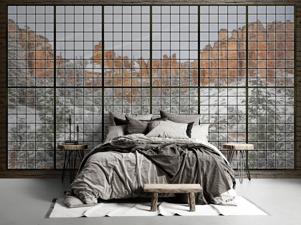 Scenic winter mountain mural wallpaper with grid window, grey bed, rustic benches, hardwood flooring.