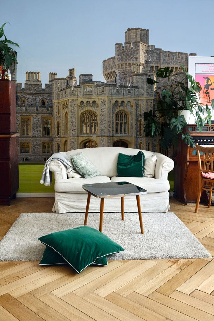 Regal Stone Castle mural wallpaper in living room, cream sofa, green cushions, parquet flooring.