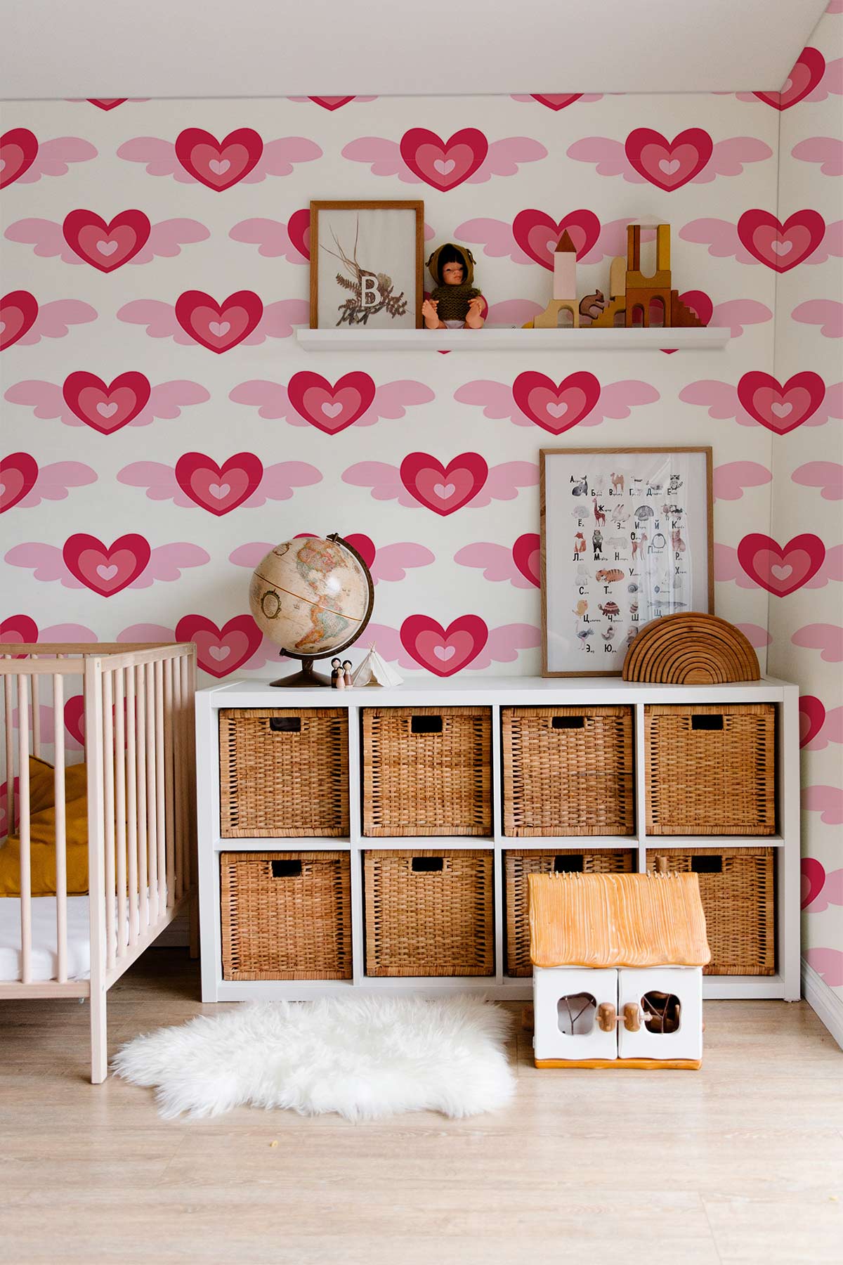 Charming Pink Heart Patterned Wallpaper in nursery with wicker storage, cot, and wooden flooring.