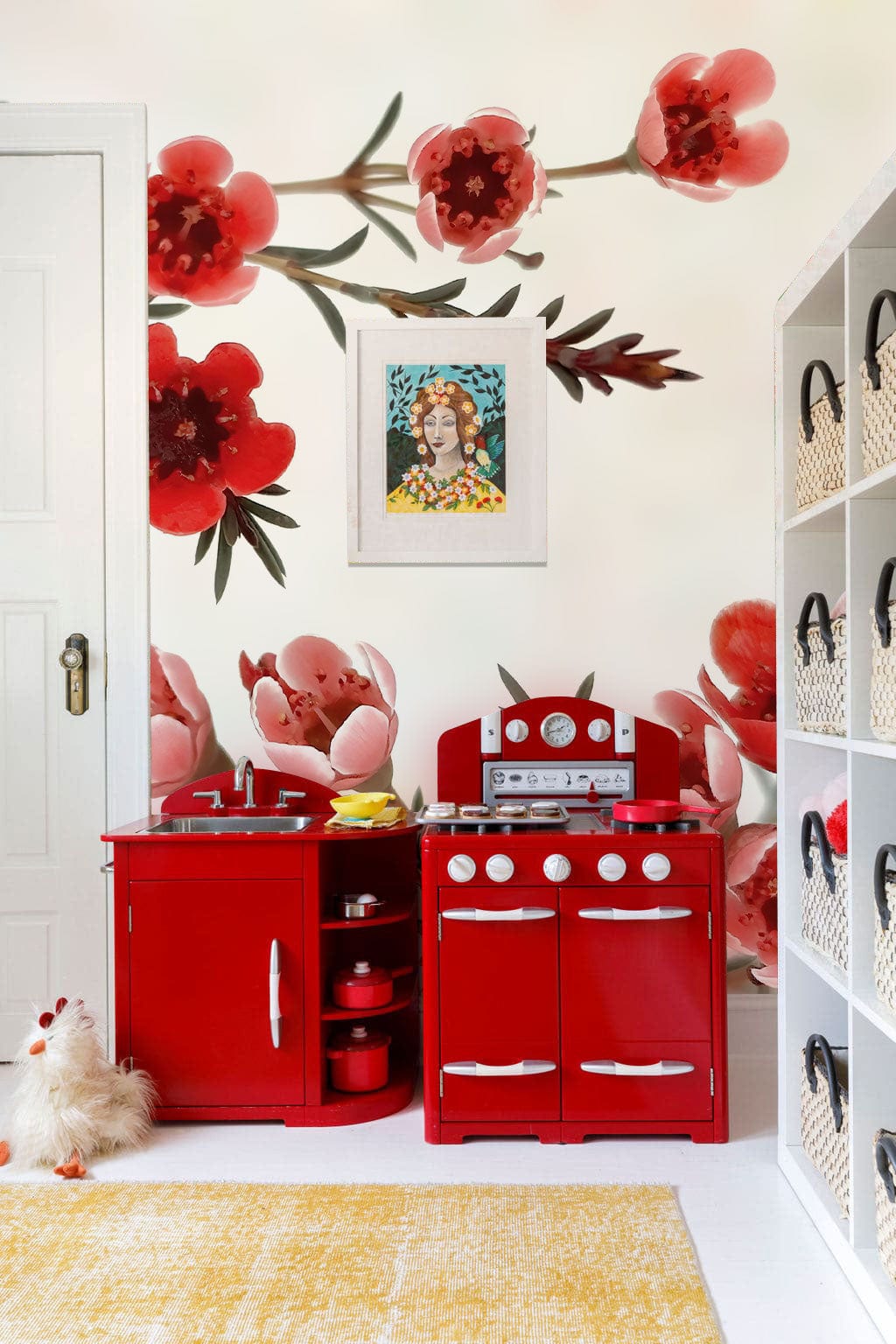Elegant red blossom mural wallpaper in children's playroom with red toy kitchen and colourful artwork.