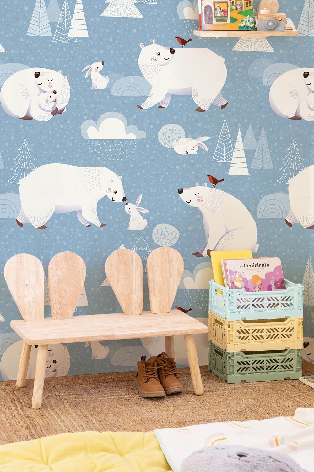 Blue kids wallpaper mural with cosy winter bears, wooden bench, rattan rug, and colourful storage baskets.