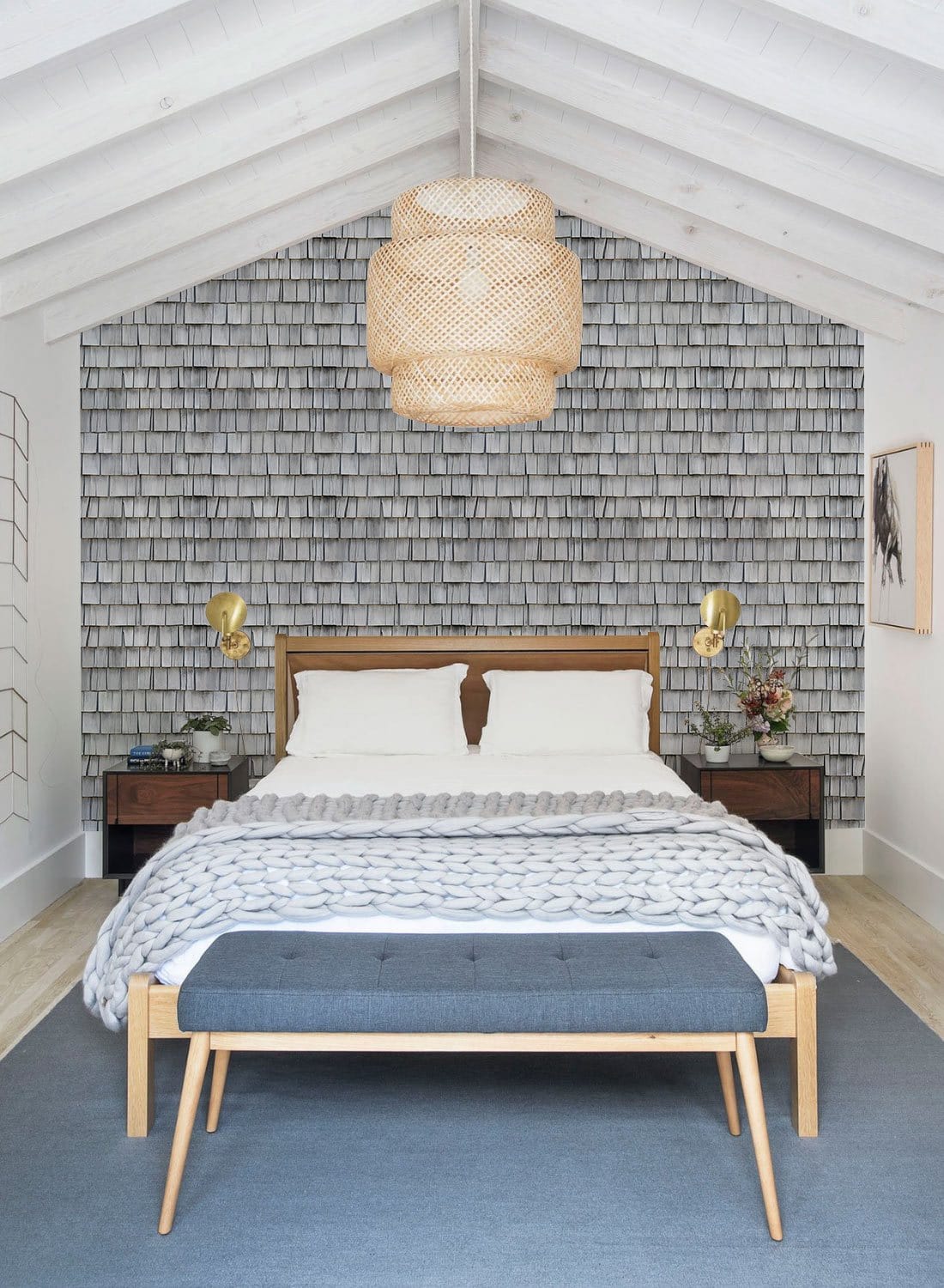Rustic grey shingle wallpaper in contemporary bedroom, featuring wooden bed, pendant light, and grey bench.