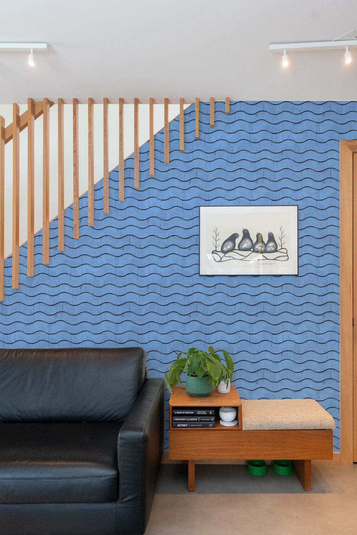 Tranquil Ocean Waves wallpaper in living room with black sofa, wooden accents, and modern decor.
