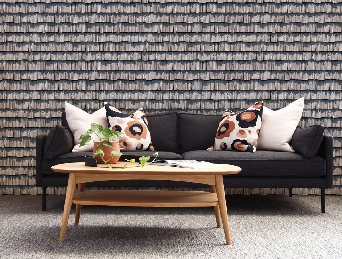Elegant grey coastal wallpaper, black sofa, wooden coffee table, modern living room, patterned cushions, rug flooring.