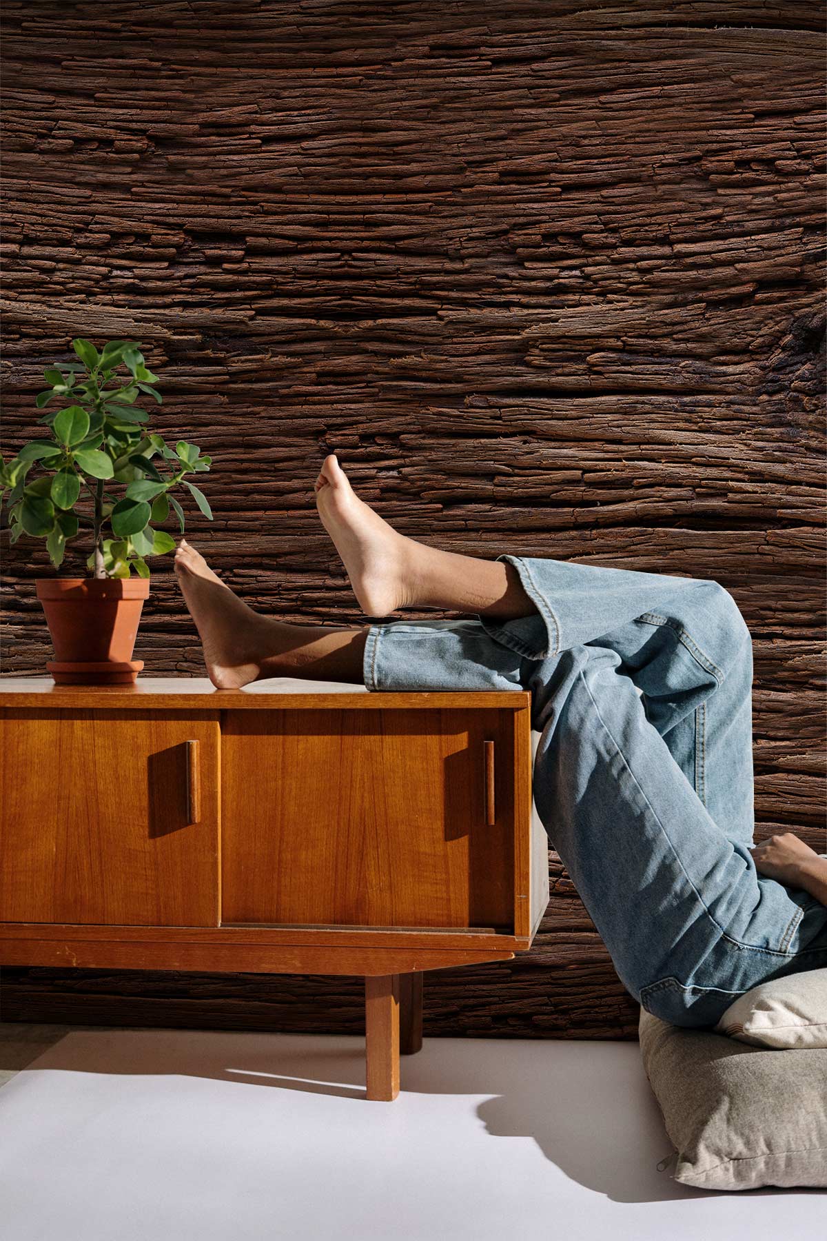 Rustic dark wood texture mural wallpaper behind mid-century cabinet in cosy living room interior.