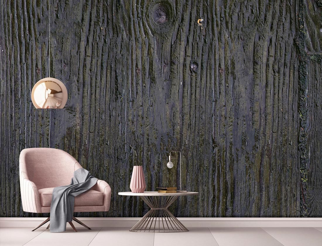 Rustic charcoal wood-texture wallpaper decor in a living room with pink armchair and modern table.
