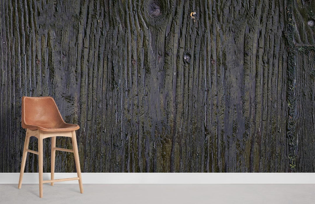 Rustic Charcoal Wood Texture Wallpaper displayed with tan leather chair, grey flooring. Dark grain detail.