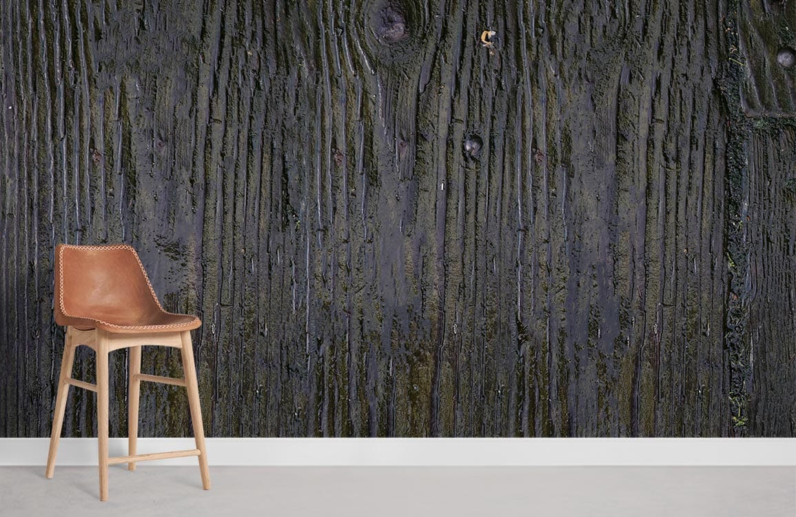 Rustic Charcoal Wood Texture Wallpaper displayed with tan leather chair, grey flooring. Dark grain detail.