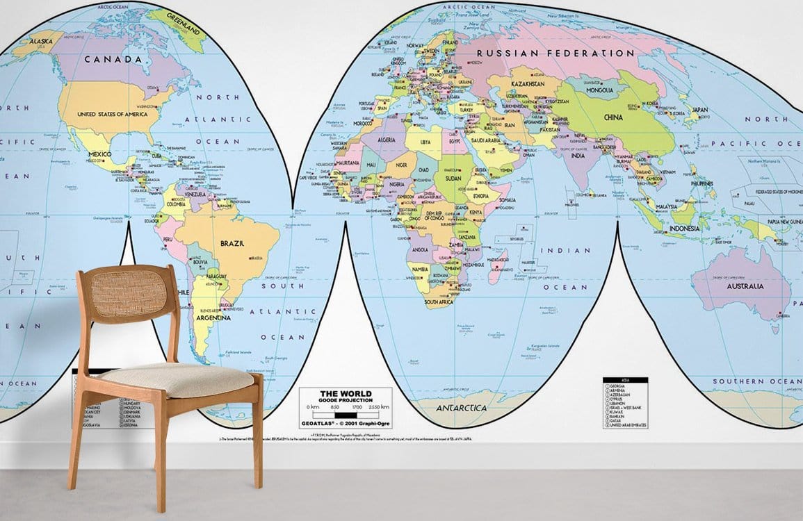 Colourful Vintage World Map Mural Wallpaper in educational room with wooden chair and white wall.