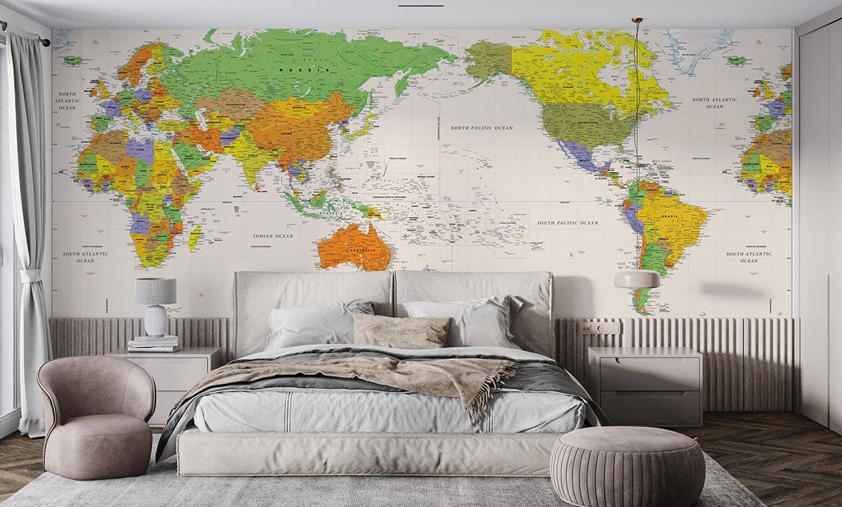 Vibrant World Map Mural Wallpaper in bedroom with grey bed, modern chairs, and wooden flooring.