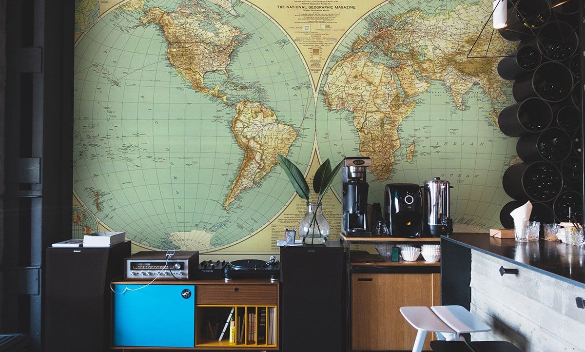 Vintage World Map Mural, antique earthy tones, bar setting, dark cabinets, minimalistic counter stools.