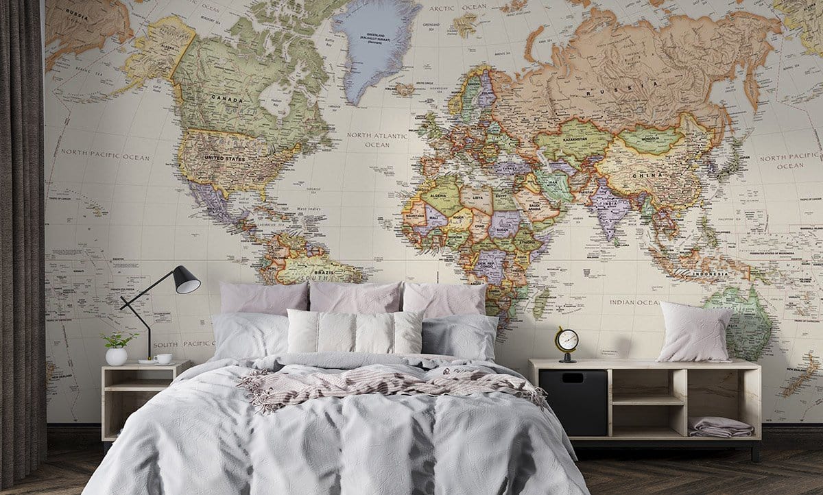 Vintage world map mural wallpaper in classic beige decor, bedroom setting, with cosy grey bedding.