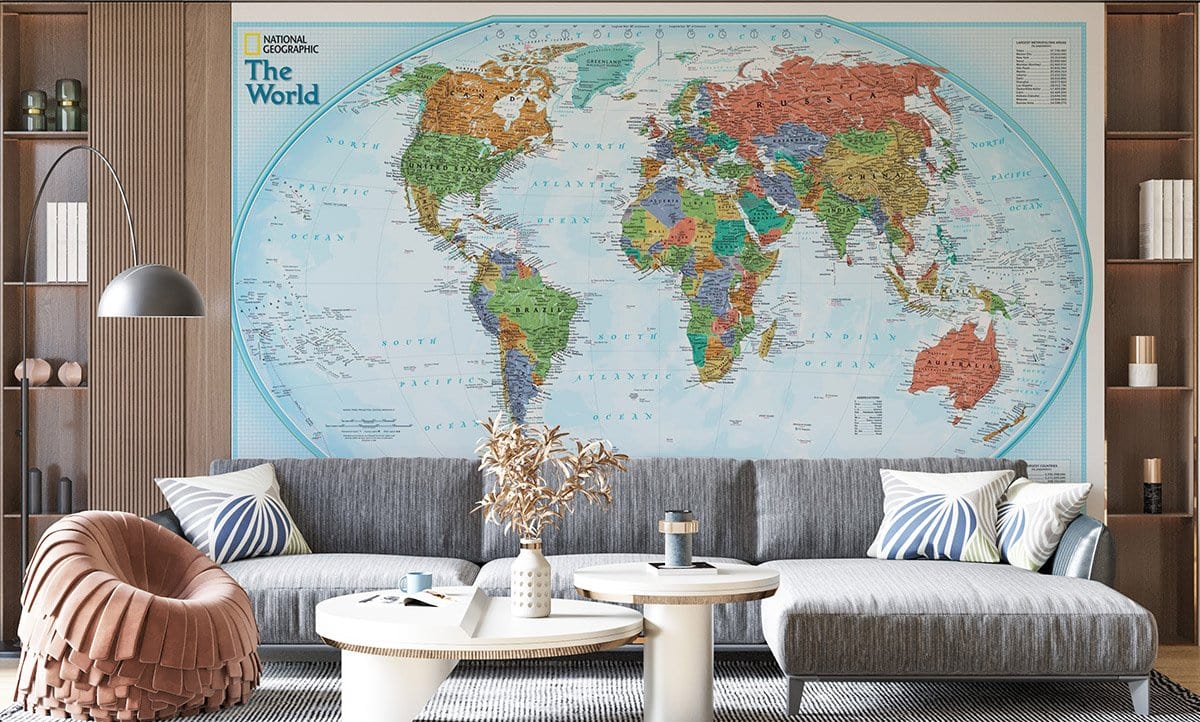 National Geographic map mural in living room with grey sofa, beige armchair, wood-panelled walls, modern decor.