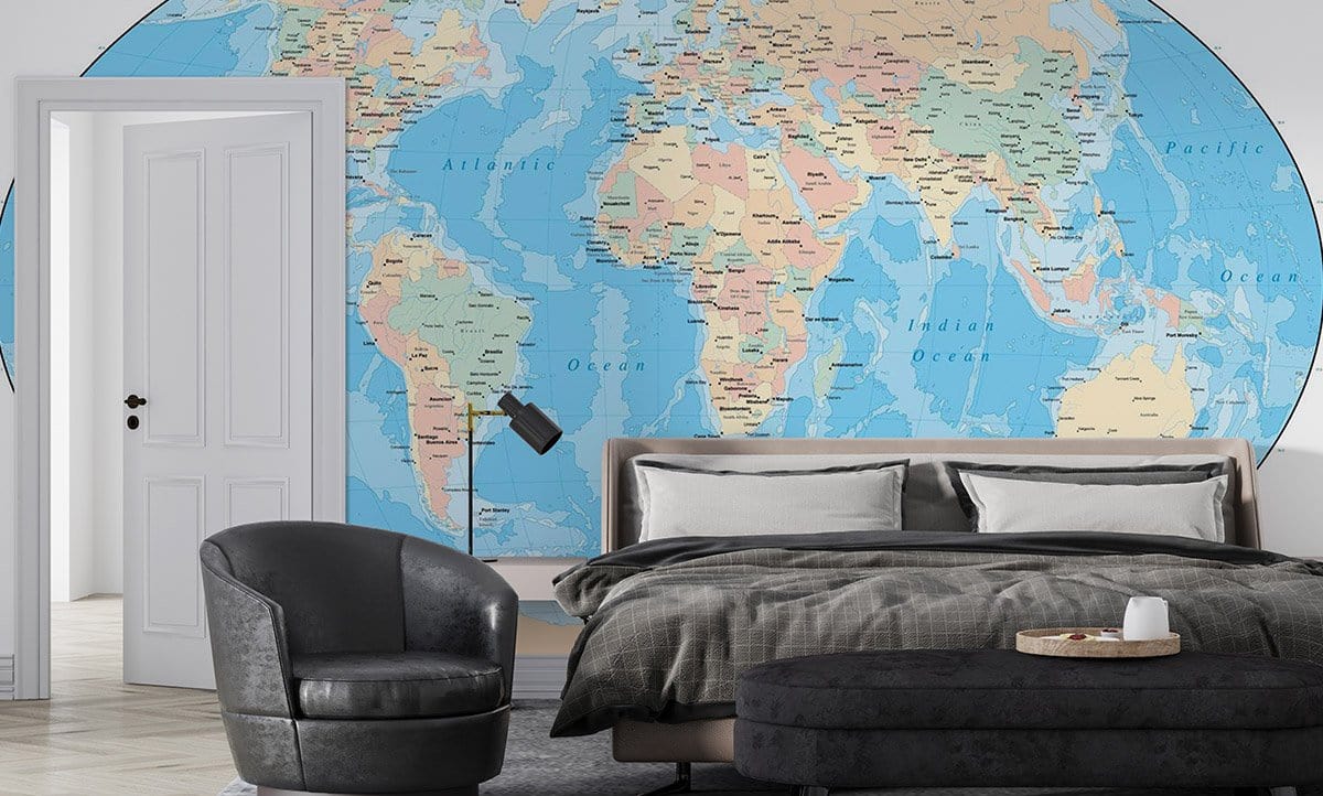 Educational world map mural in soft blue and beige tones, bedroom with grey armchair and bed.