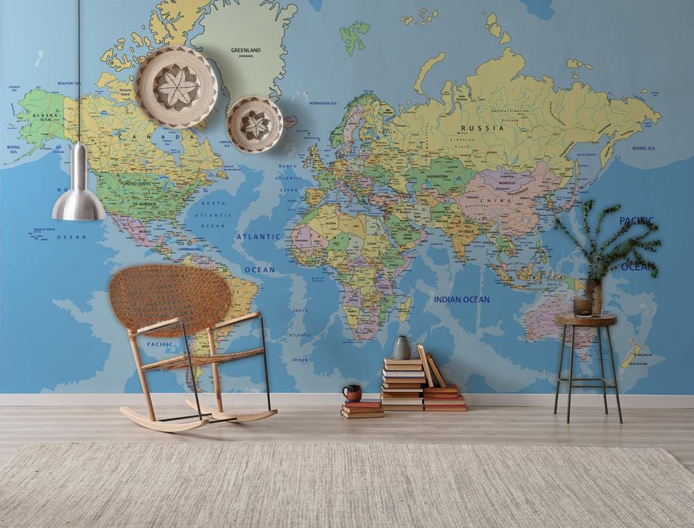 Vintage world map mural wallpaper in pastel colours, wooden rocking chair, modern lighting, and beige rug.