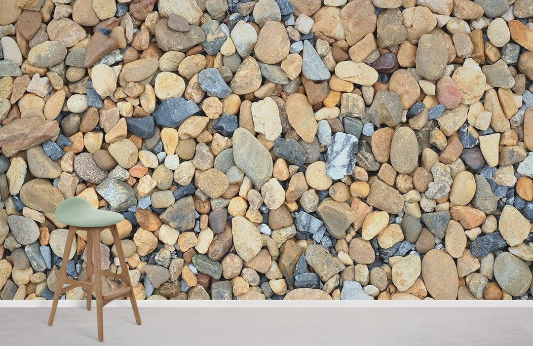 Natural Pebble Stone Texture Wallpaper in rustic grey, earth tones, complements modern stool on wood flooring.